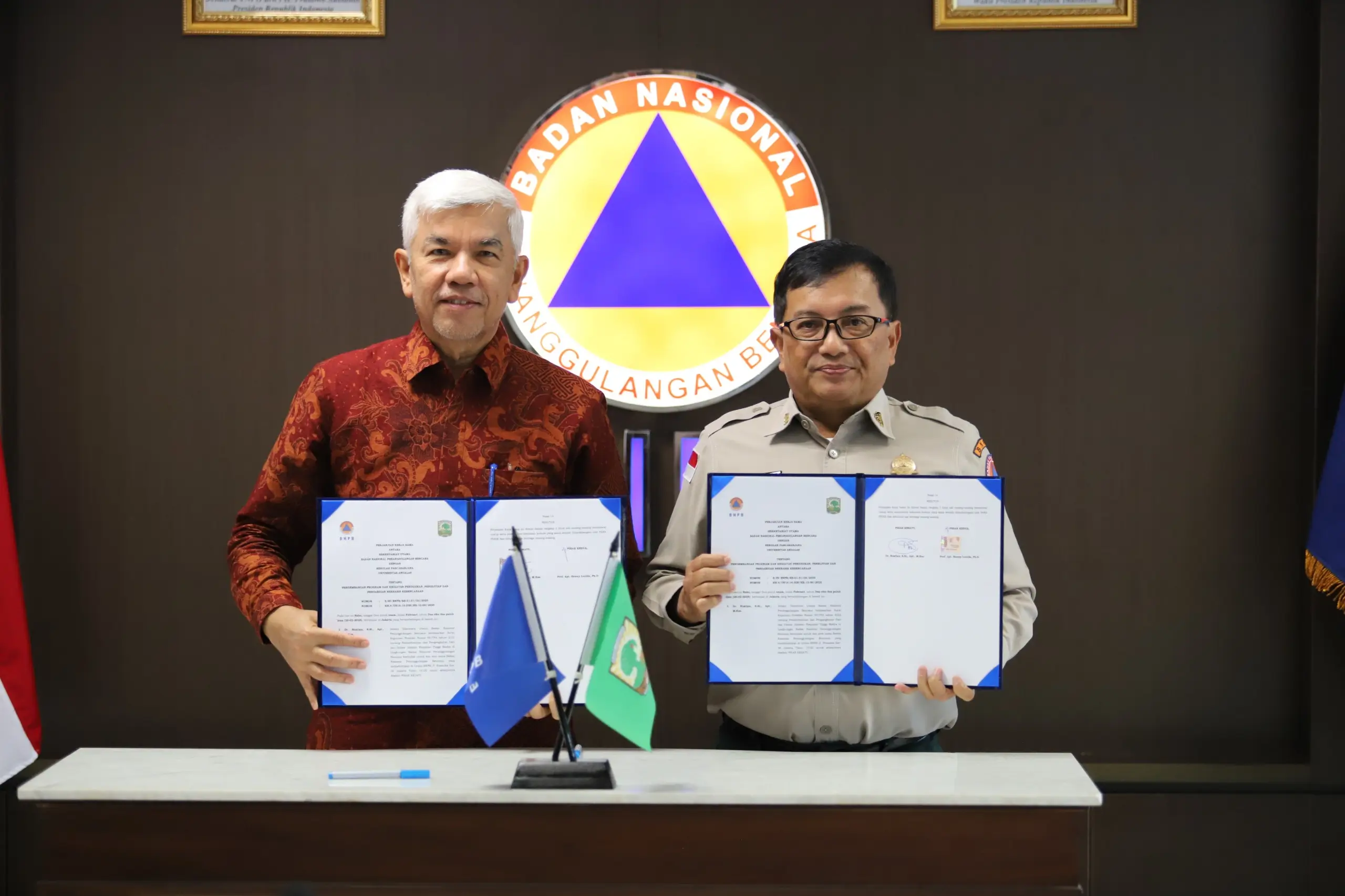 Sekretaris Utama BNPB Dr. Rustian, S. Si., Apt., M.Kes dan Wakil Rektor 1 Prof. Dr. Syukri Arief memperlihatkan dokumen perjanjian kerjasama di Graha BNPB, Jakarta pada Rabu (26/2).